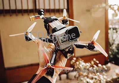 FPV racing drone held in hand with an Ovonic 6S LiPo battery mounted on top for flight power