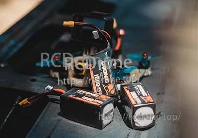 Ovonic 120C 22.2V 6S 1600mAh LiPo battery packs next to an FPV racing quad with XT60 lead