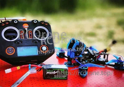 Ovonic 6S 1000mAh LiPo battery next to FPV radio transmitter and quadcopter for scale