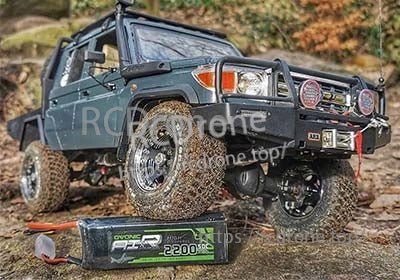 Ovonic 2200mAh 3S LiPo pack on the ground beside a mud-ready RC crawler, highlighting compact size