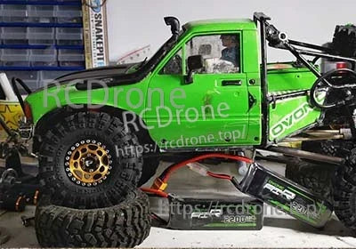 Ovonic 3S 2200mAh 50C 11.1V LiPo battery with XT60 plug next to green RC rock crawler truck