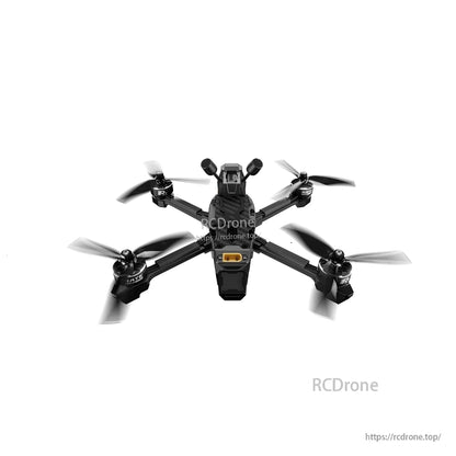 Underside view of the quadcopter frame with four motors, propellers, and orange connector