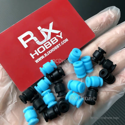 RJX 100pcs 13x9x3.5mm Silicone Damping Ball, Assorted blue and black RJX silicone damping balls in a hand, small spool-shaped vibration dampers.