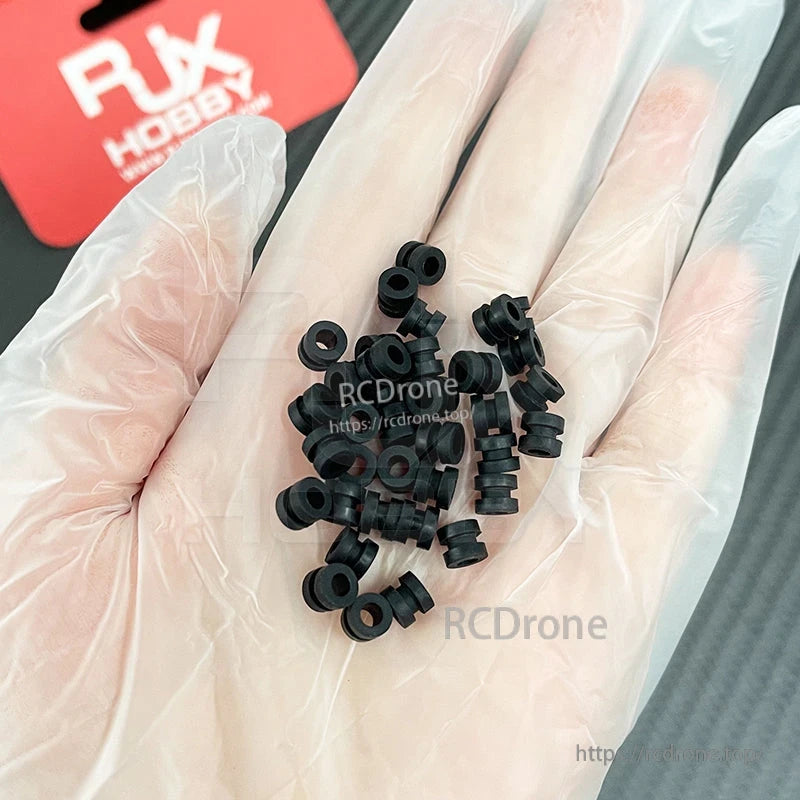 RJX 100pcs 3x5x6mm Damping Ball, Hand holding small black rubber damping balls/grommets for RC builds, RJX 3x5x6mm size