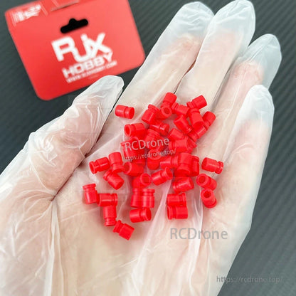 RJX 100pcs 3x5x7mm Damping Ball, Hand holding small red RJX damping balls for RC models, assorted rubber vibration dampers