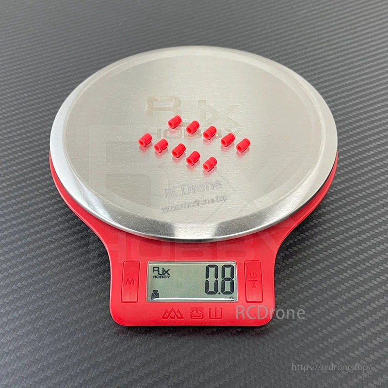 RJX 100pcs 3x5x7mm Damping Ball, Small red RJX damping balls on a digital scale, showing a 0.8 g weight reading