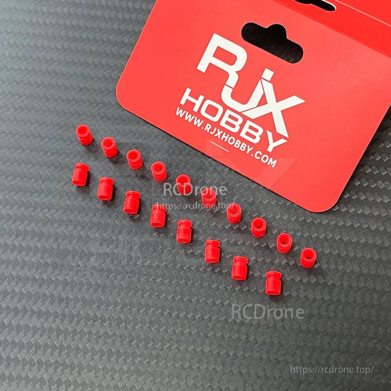 RJX 100pcs 3x5x7mm Damping Ball, RJX Hobby red damping balls/grommets laid out on a carbon-fiber surface with RJX packaging