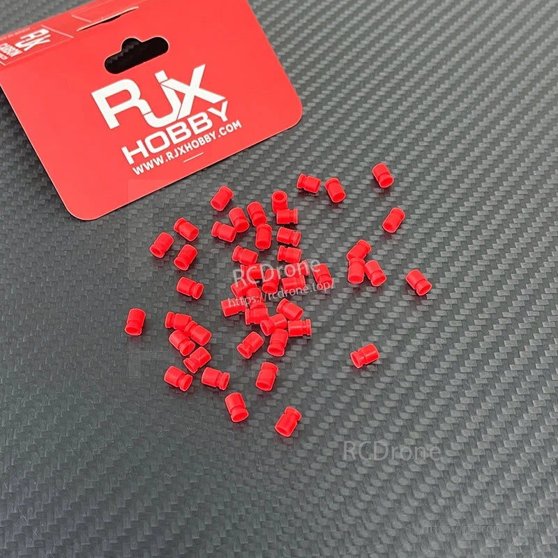 RJX 100pcs 3x5x7mm Damping Ball, RJX Hobby red damping balls in small cylindrical shape, loose pieces on a carbon-fiber pattern surface