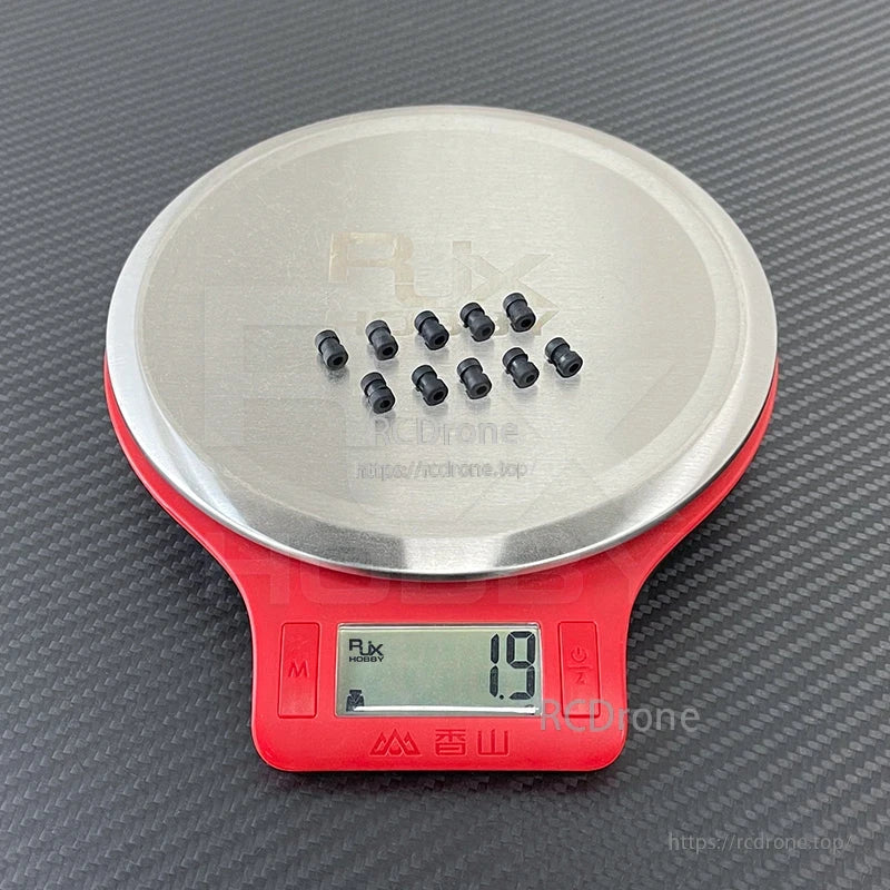 RJX 100pcs Damping Ball, Small black rubber damping balls on a digital scale, showing 1.9 g for the sample set