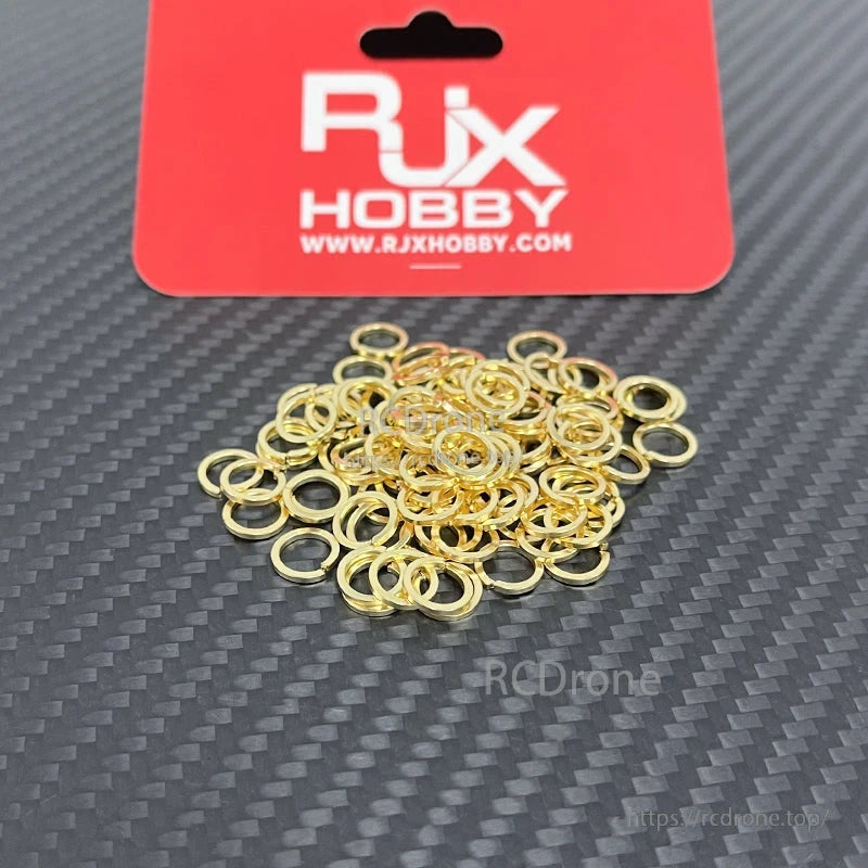 Pile of gold-colored SMA tooth lock washers and gaskets from RJX Hobby for SMA female connectors