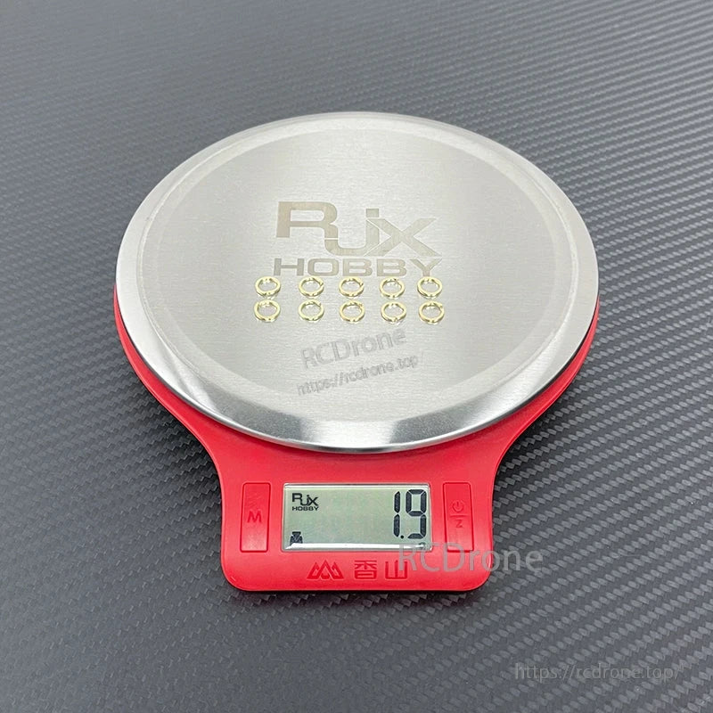 Small gold SMA connector tooth washers set on a digital scale, total weight reading 1.9 g
