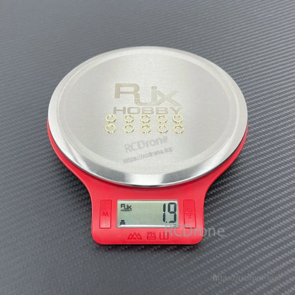 Small gold SMA connector tooth washers set on a digital scale, total weight reading 1.9 g