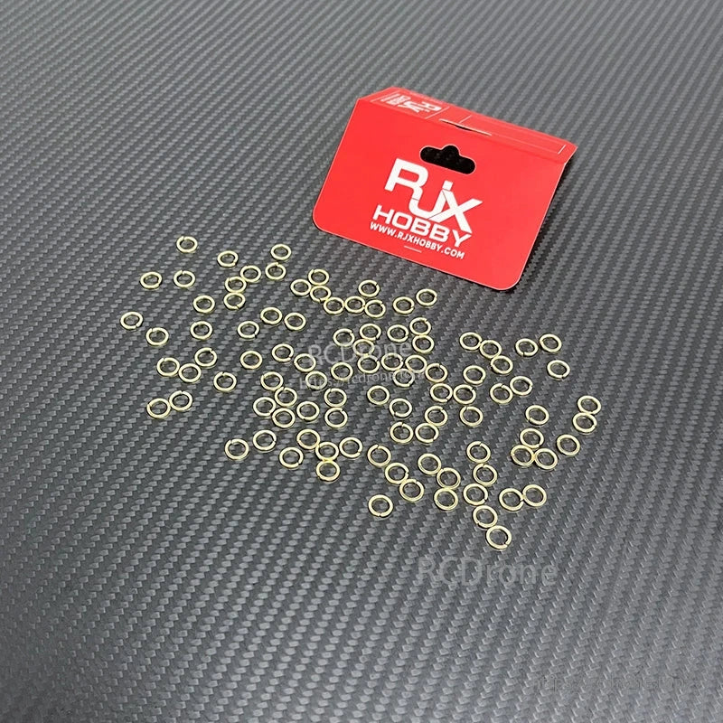 RJX Hobby small gold tooth lock washers for SMA female connector nuts, loose pack on carbon-fiber surface