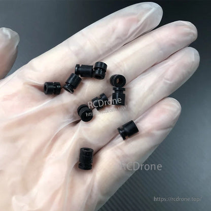 RJX 100pcs Silicone Anti‑Vibration Damping Ball, Small black silicone anti-vibration damping balls/grommets held in a hand for RC or drone mounting