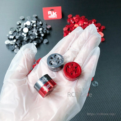 RJX quick release self-tightening prop adapters in red and silver with CW/CCW arrow markings for multirotor motors