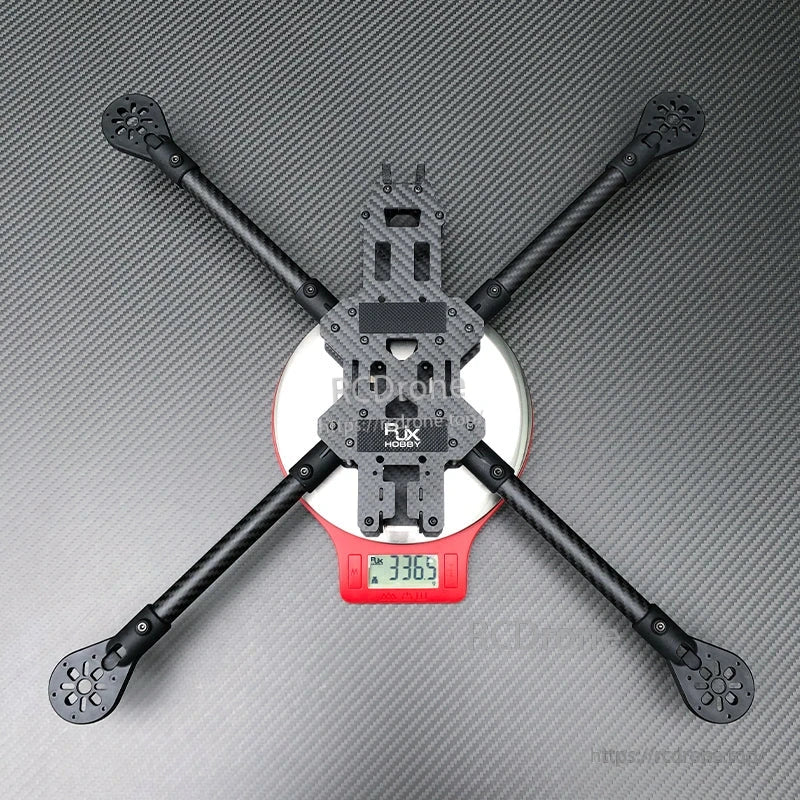 RJX 13-inch carbon fiber FPV racing drone frame kit in X layout with four arms, shown on a digital scale