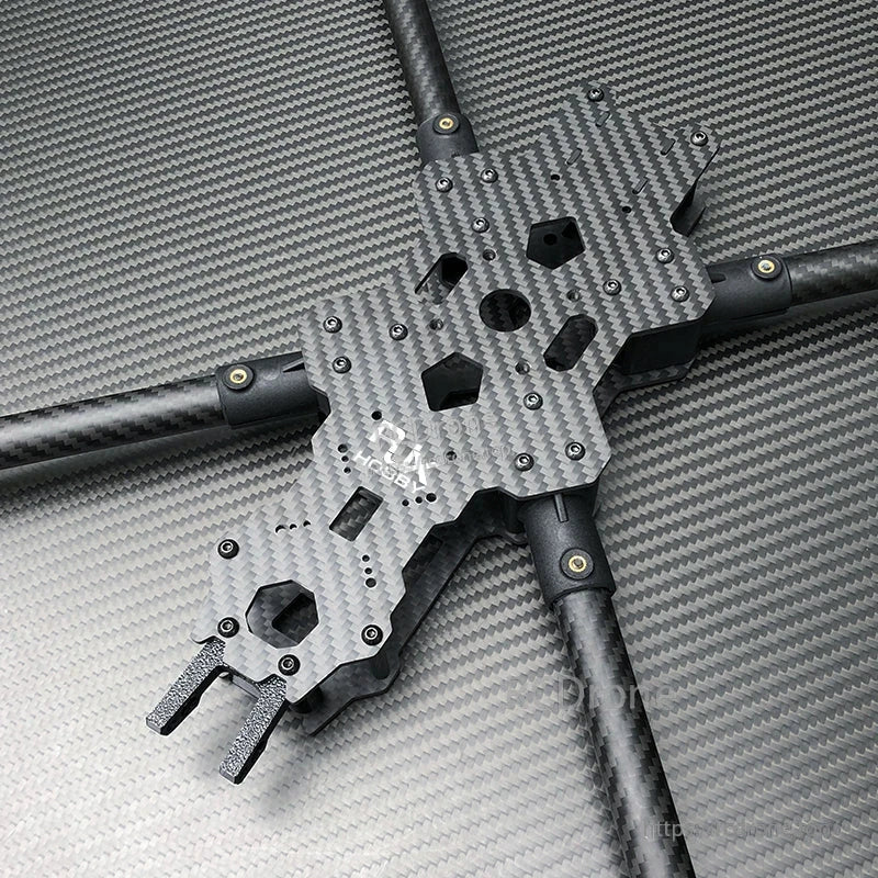 Top plate and center section of a carbon fiber FPV racing drone frame with long tubular arms and mounting holes