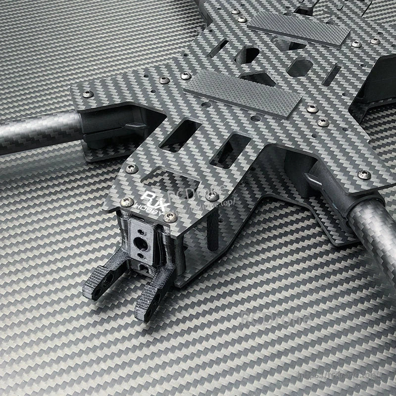 Close-up of RJX carbon fiber FPV drone frame kit with slotted top plate, arms, and front camera mount bracket