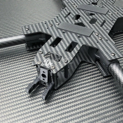 Close-up of RJX carbon fiber FPV drone frame kit with slotted top plate, arms, and front camera mount bracket