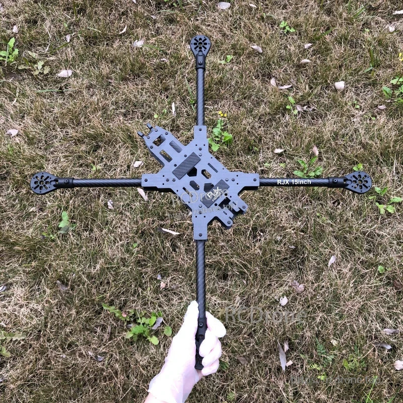 RJX 15inch carbon fiber FPV drone frame kit with long arms and central plate layout, held over grass