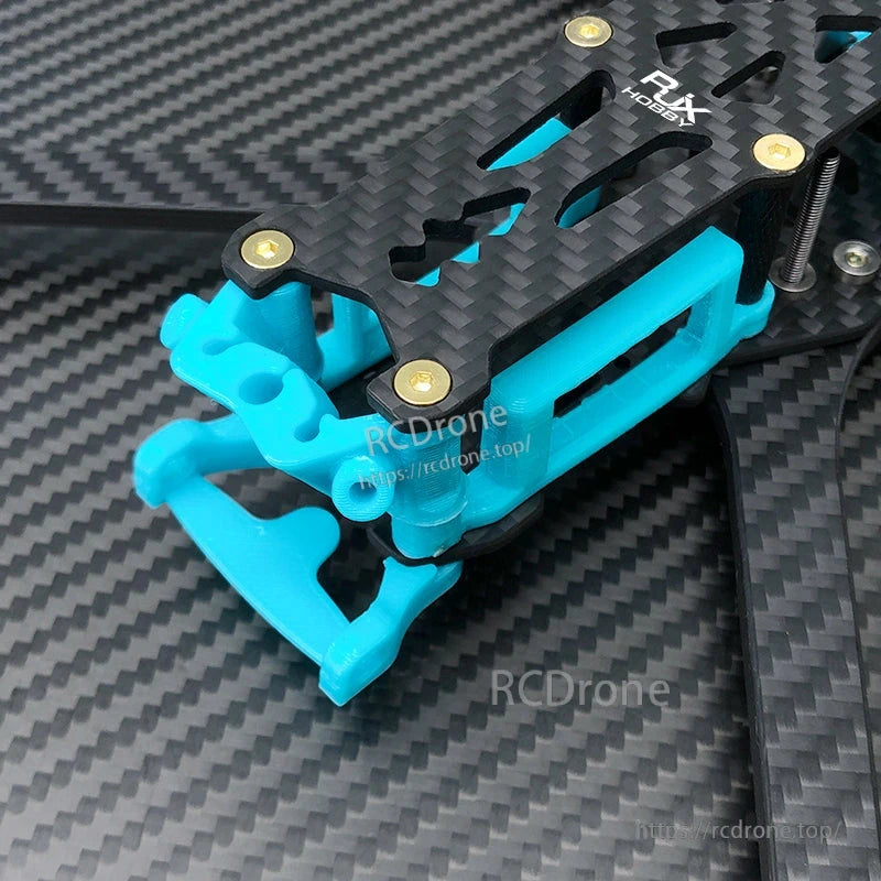 Blue 3D-printed RJX camera mount parts installed on a carbon fiber FPV drone frame with hardware