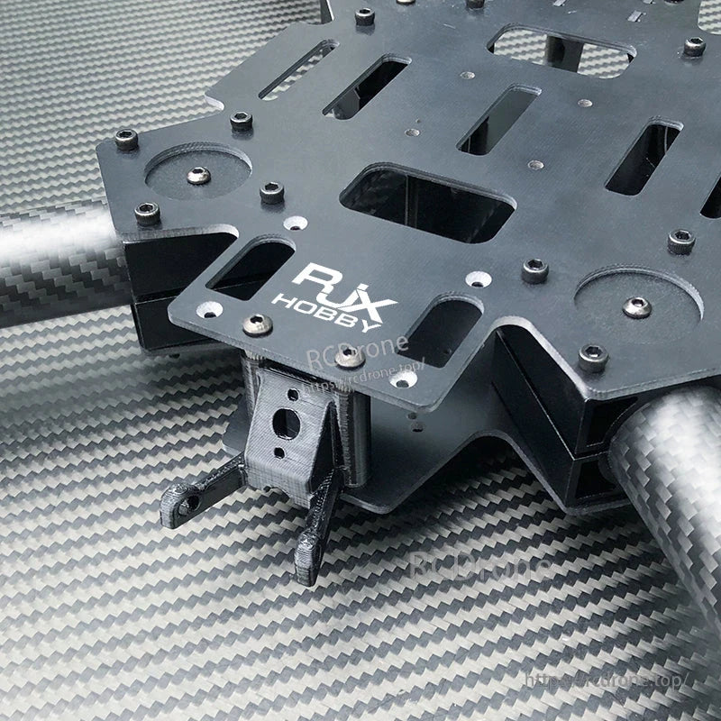 Close-up of RJX Hobby quadcopter frame center plate with carbon fiber tubes and slotted mounting holes