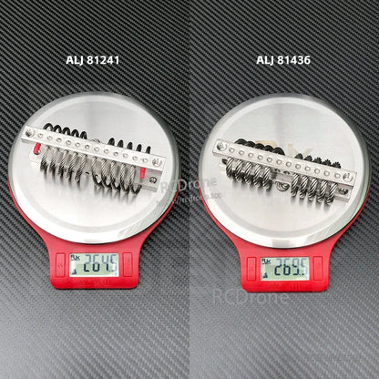 Two M5 steel wire rope vibration isolators on digital scales, labeled ALJ 81241 and ALJ 81436 at ~26g