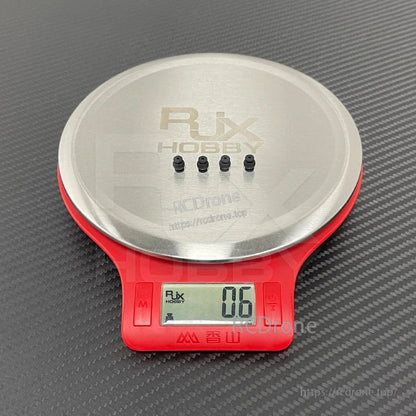 RJX 50pcs 1.5x6x8mm / 1.5x6x8.8mm Damping Ball, Four small RJX Hobby damping balls on a digital scale, showing a 0.6 g reading for lightweight vibration isolation