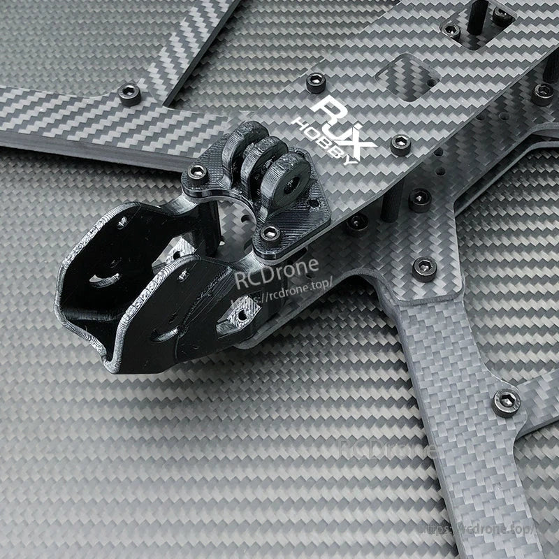 Close-up of RJX Hobby carbon fiber FPV drone frame plates with screws and a black 3D-printed mount bracket