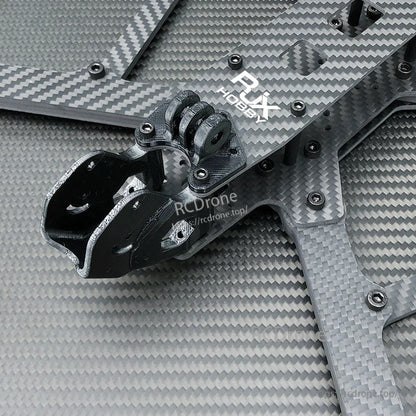 Close-up of RJX Hobby carbon fiber FPV drone frame plates with screws and a black 3D-printed mount bracket