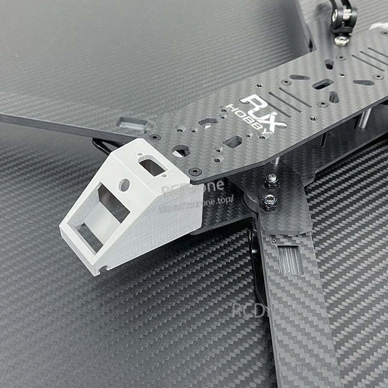 Close-up of RJX Hobbies carbon fiber FPV drone frame with front camera mount and arm hardware