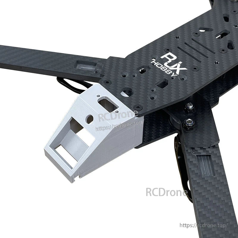 Close-up of RJX carbon fiber FPV drone frame with RJX Hobby top plate and white front camera mount bracket