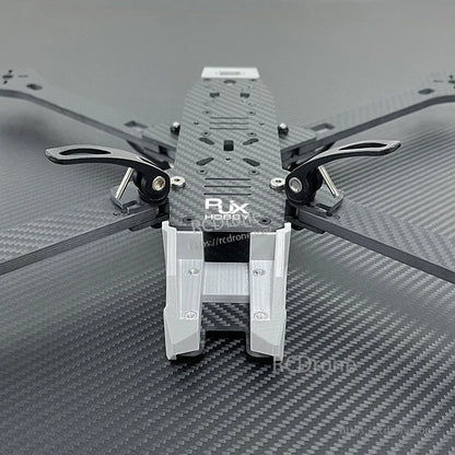 Close-up of RJX A4 carbon fiber FPV racing drone frame with metal standoffs and a 3D-printed front mount.