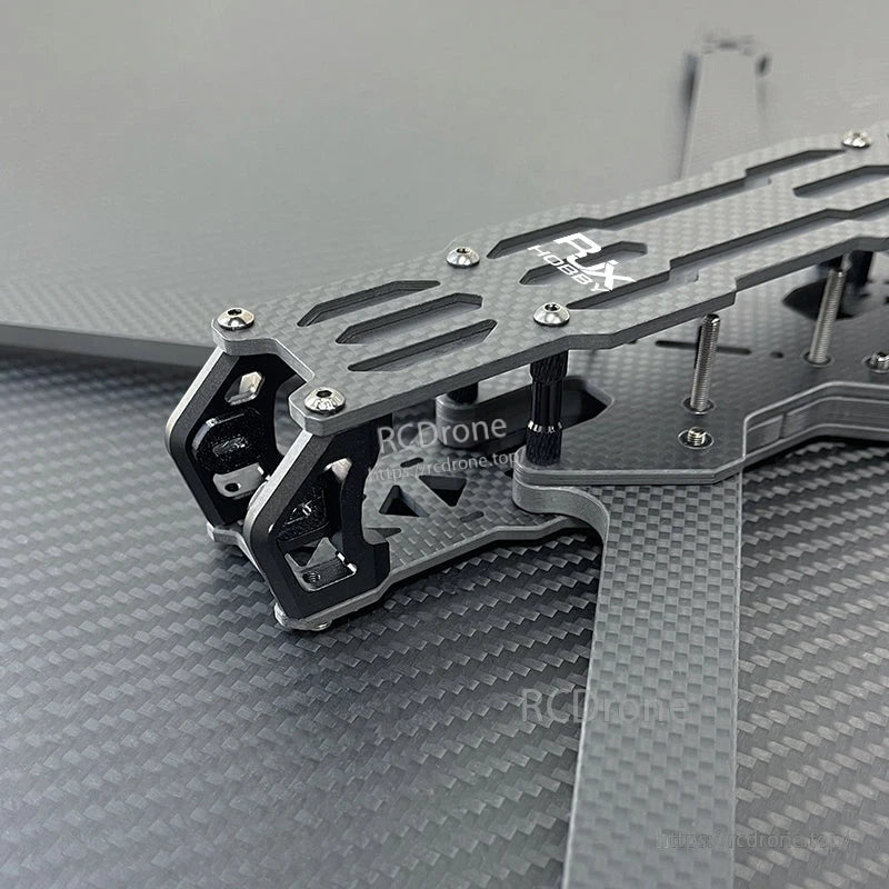 Close-up of RJX A5 carbon fiber FPV drone frame top plate with metal camera mount and standoff hardware