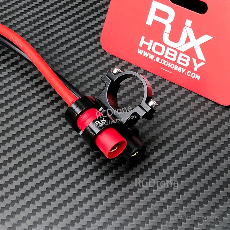 RJX AS150 holder mount with red and black AS150 battery connectors and clamp bracket on carbon-fiber surface