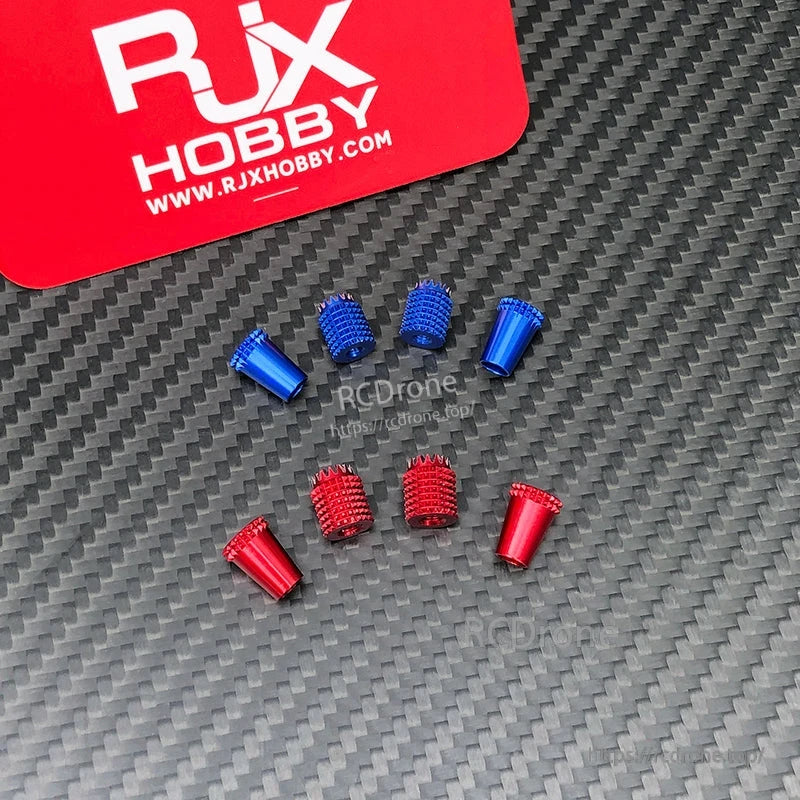 RJX aluminum gimbal thumb stick tips in red and blue, knurled and smooth styles, laid out on carbon fiber