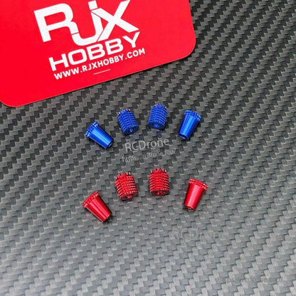 RJX aluminum gimbal thumb stick tips in red and blue, knurled and smooth styles, laid out on carbon fiber