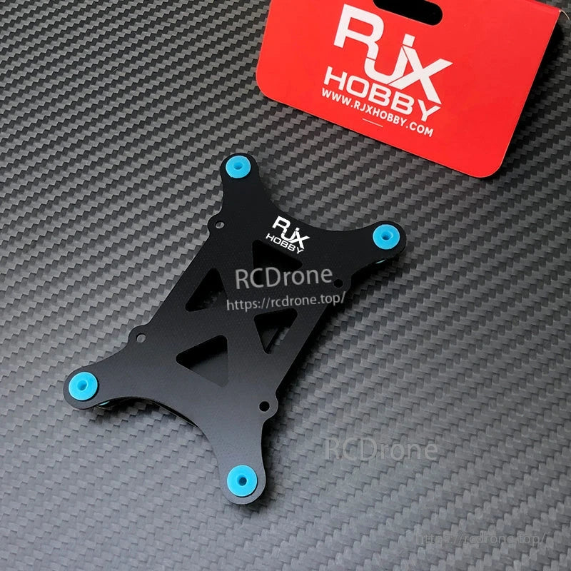 RJX Anti-Vibration Flight Controller Mount, RJX Hobby anti-vibration flight controller mount plate with four blue rubber dampers on a carbon-fiber surface