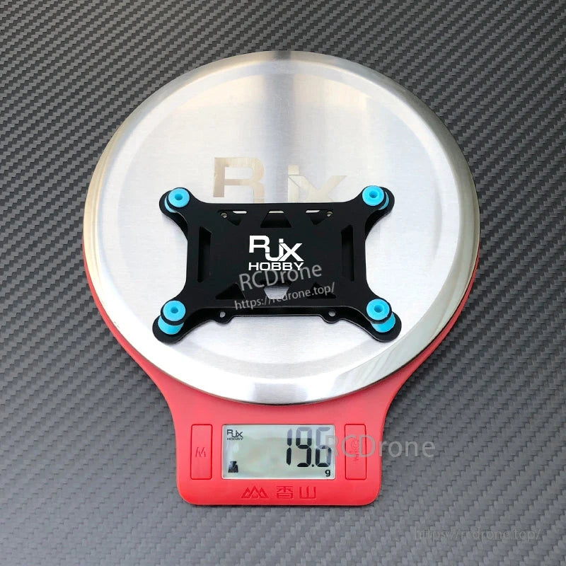 RJX anti-vibration flight controller mount plate with four blue rubber dampers on a digital scale (19.6 g)