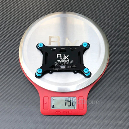 RJX anti-vibration flight controller mount plate with four blue rubber dampers on a digital scale (19.6 g)