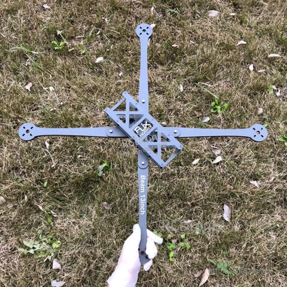 RJX Beam 13inch carbon fiber FPV racing drone frame kit with X arms and center plate laid on grass