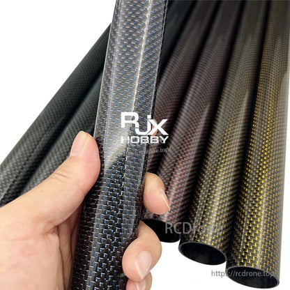 RJX Colored 3K Carbon Fiber Tube, Hand holding RJX 3K carbon fiber tube with blue weave finish, with other colored carbon tubes in the background