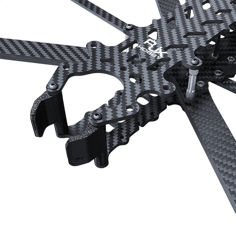 Close-up of carbon fiber FPV drone frame kit top plate with arm mounts, standoffs, and front TPU camera mount