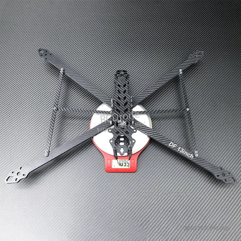 RJX DF13 13-inch carbon fiber FPV drone frame in X layout with four arms and center plates on a scale