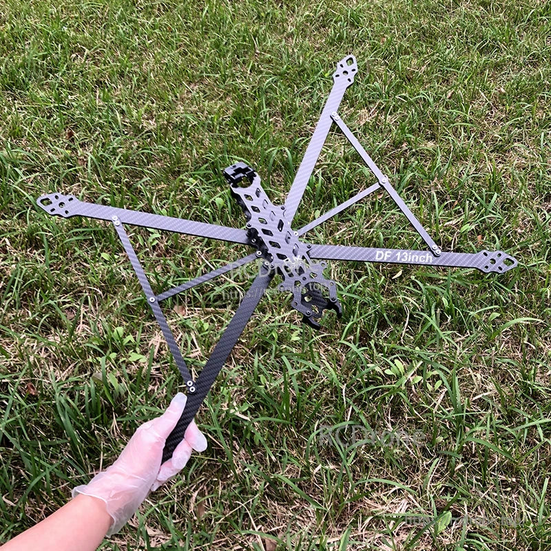 RJX DF 13-inch carbon fiber FPV drone frame kit with wide X layout arms and center plate, held outdoors