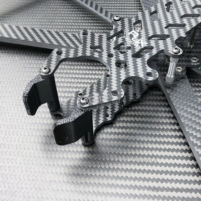 Close-up of carbon fiber FPV drone frame plates with black TPU mounts, aluminum standoffs, and screws