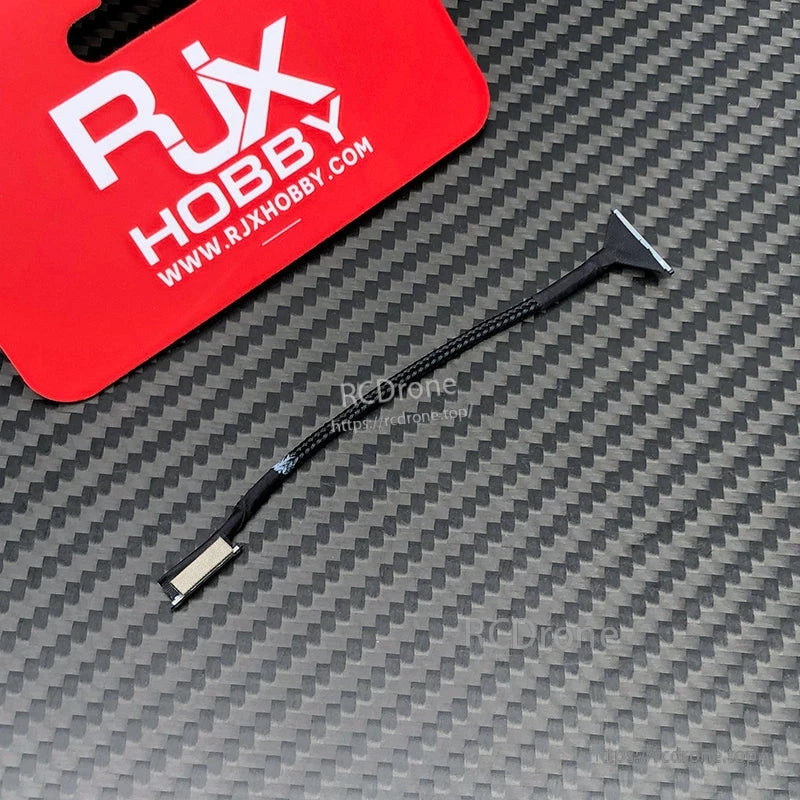 RJX DJI O3 Compatible Coaxial Cable, RJX DJI O3 compatible braided coaxial cable with small end connectors on a carbon-fiber pattern surface