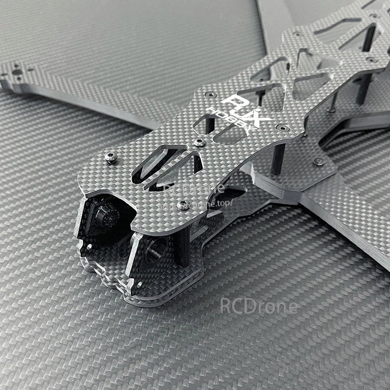 Close-up of RJX GK carbon fiber FPV racing drone frame top plate with cutouts, standoffs, and arms