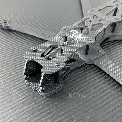 Close-up of RJX GK carbon fiber FPV racing drone frame top plate with cutouts, standoffs, and arms