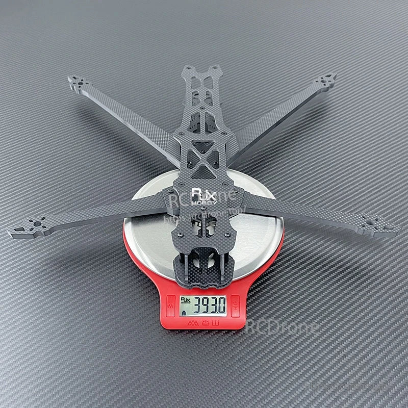 RJX GK 10-inch carbon fiber FPV drone frame laid on a digital scale, showing about 393 g